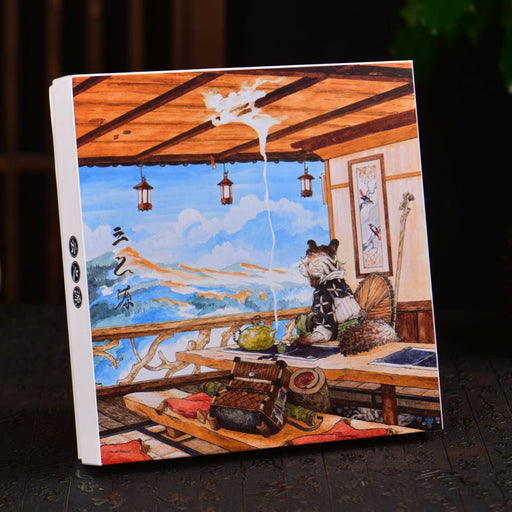 Notebook with a panda design on a dark surface with decorative items.